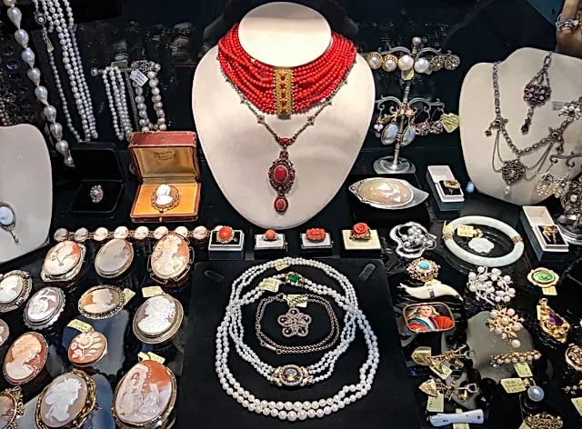 antique jewelry pieces, including necklaces, bracelets, and rings, displayed