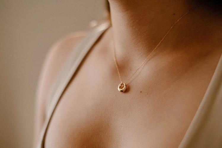 A minimalist gold necklace with a simple pendant.