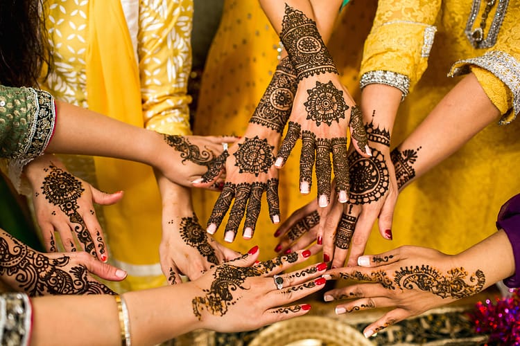 A photo of a woman's hand adorned with intricate henna jewelry designs.