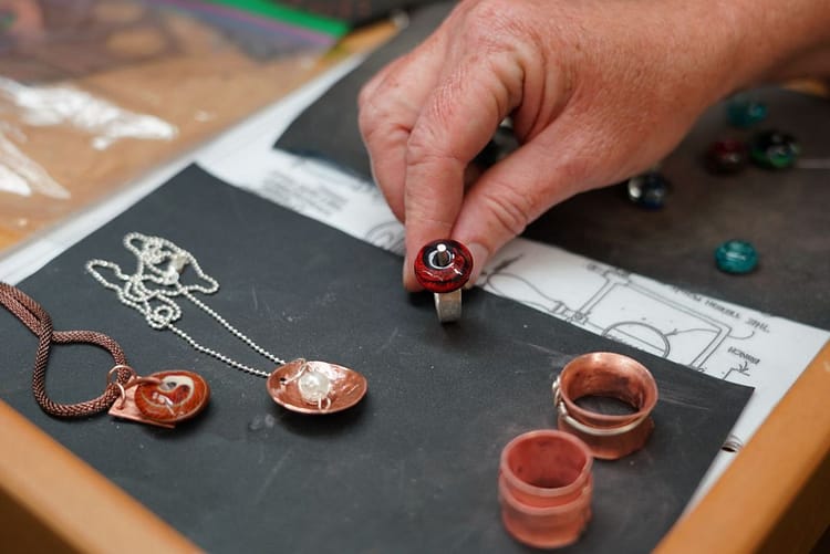 A photograph of a unique custom jewelry design with a variety of materials, shapes, and colors