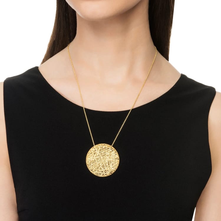 A gold necklace with a large, round pendant
