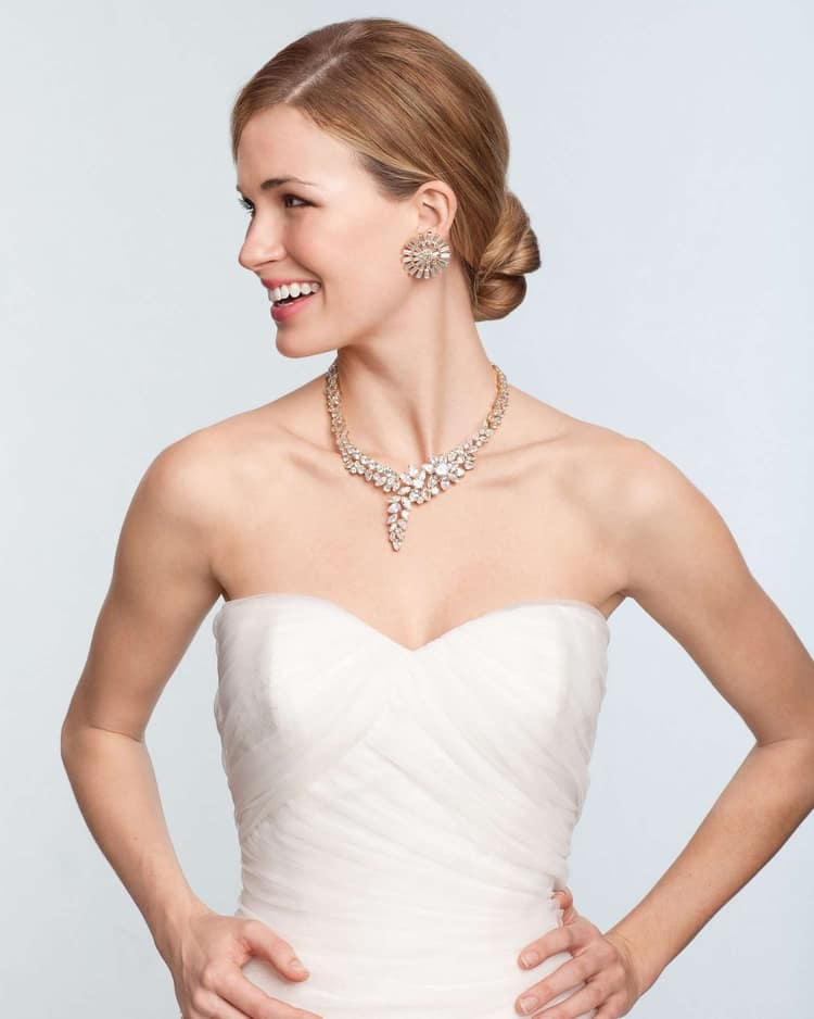 a bride wearing a diamond necklace and earrings