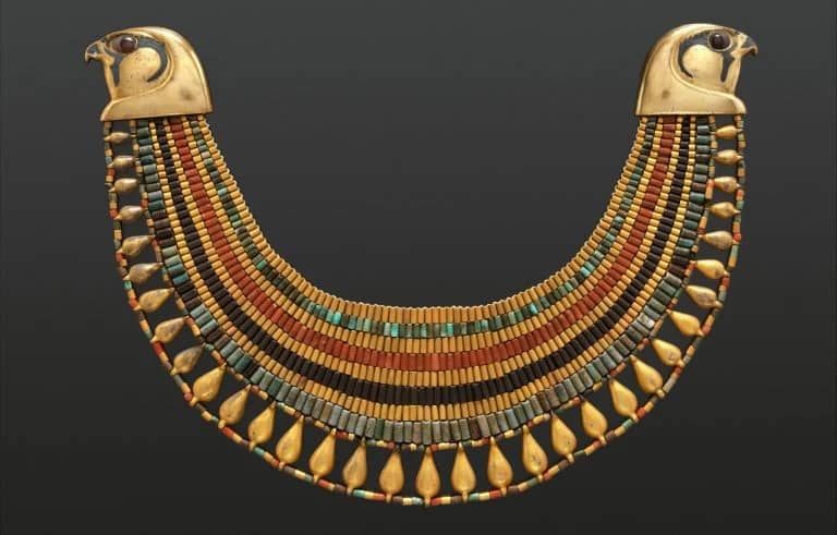 an ancient Egyptian gold necklace with intricate carvings.