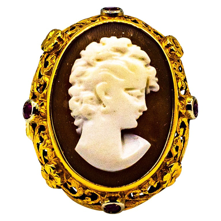 A gold pendant featuring a carved ivory cameo of a woman with intricate detailing around the edges