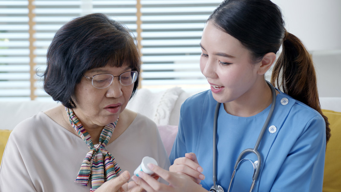 A caregiver, senior, and healthcare provider in a discussion about medication safety.