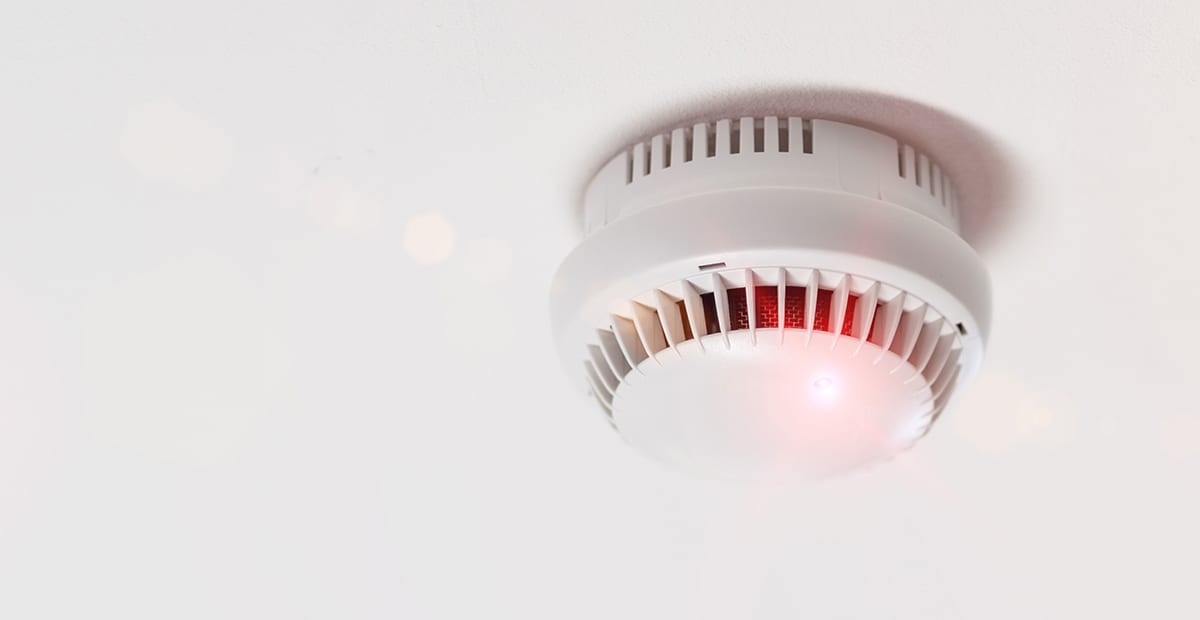 A smoke alarm is installed on a ceiling