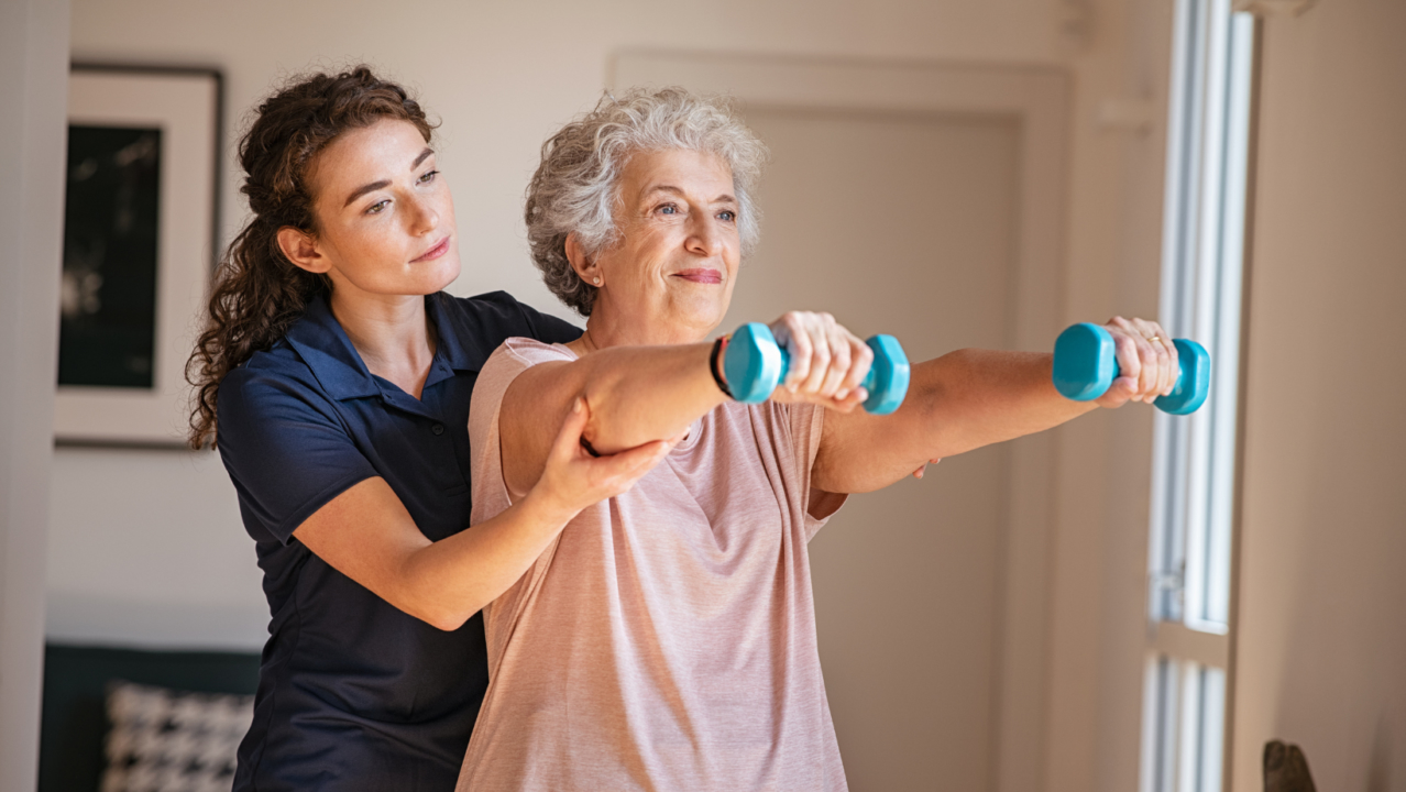 Caregiver assisting patient with mobility exercises