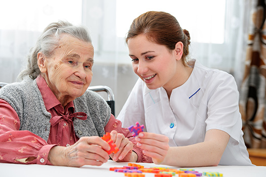 caregiver assisting a senior in cognitive stimulation activities.