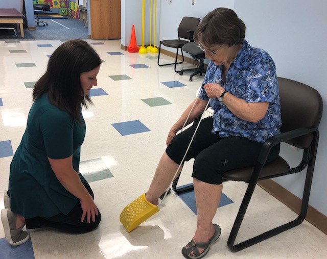 therapist assisting a patient with daily activities.