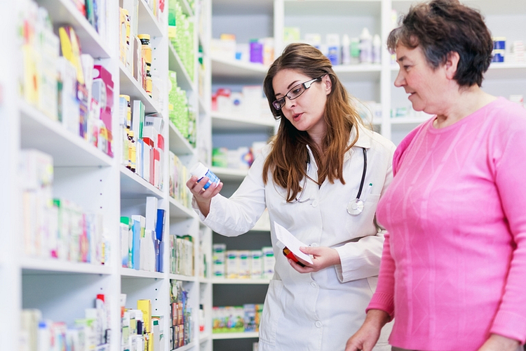 A pharmacist explaining medication instructions to a senior patient.